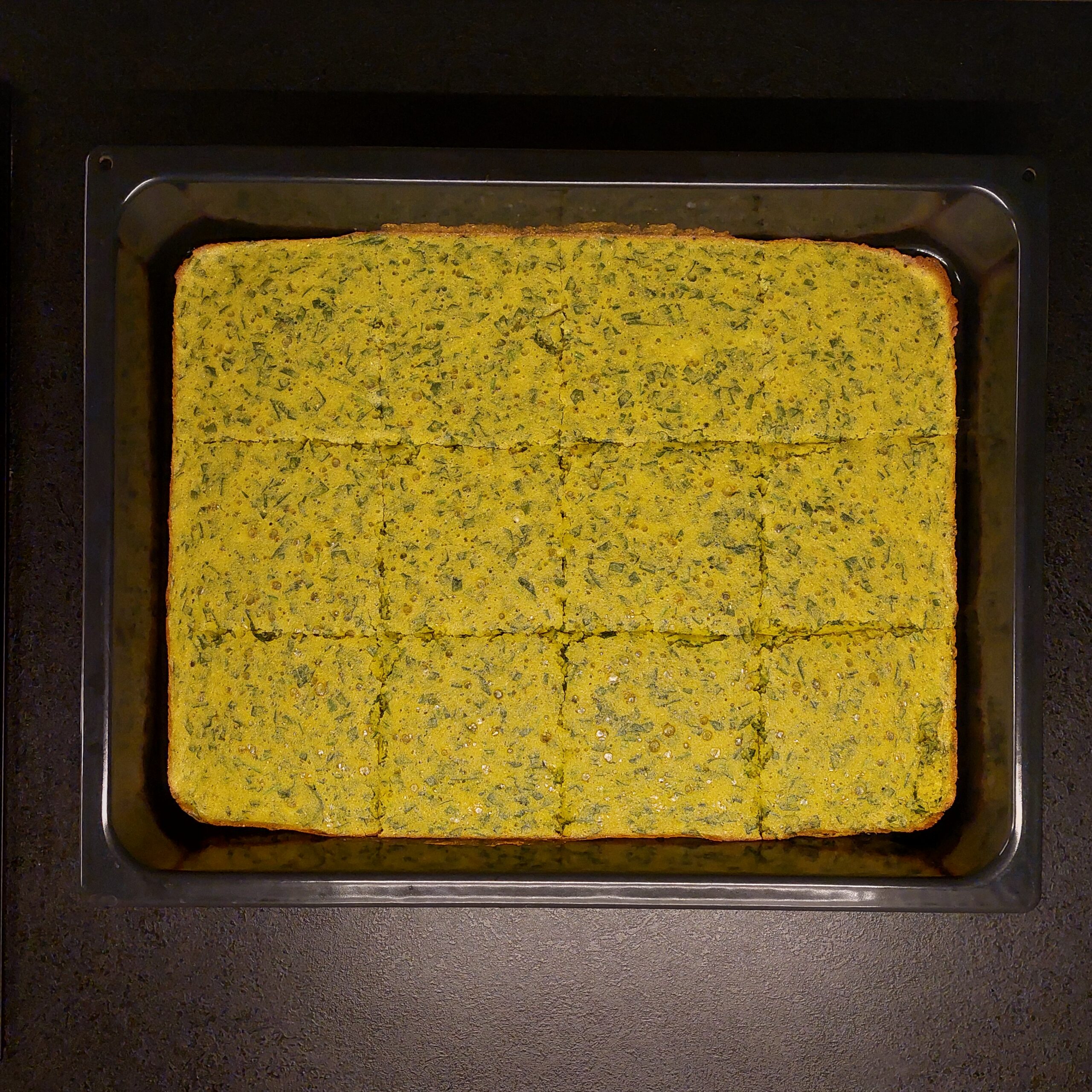 fully baked cornbread with spinach in a tray