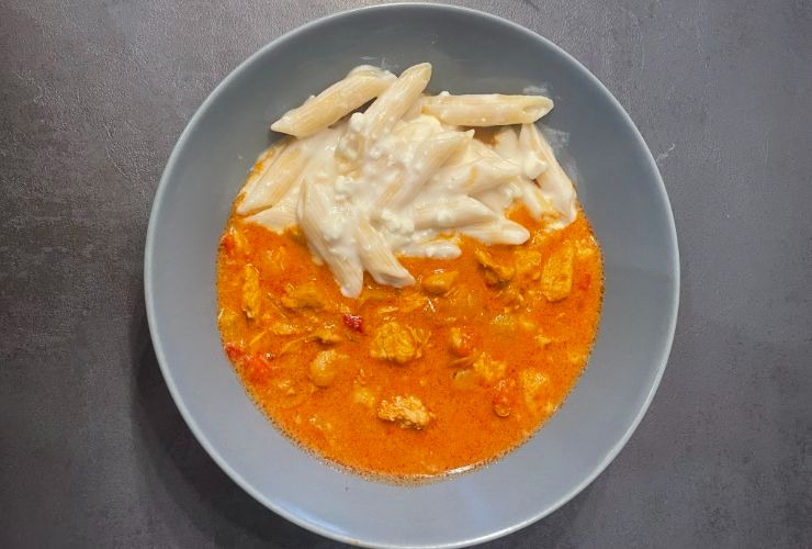 chicken goulash with mac and cheese served in a plate