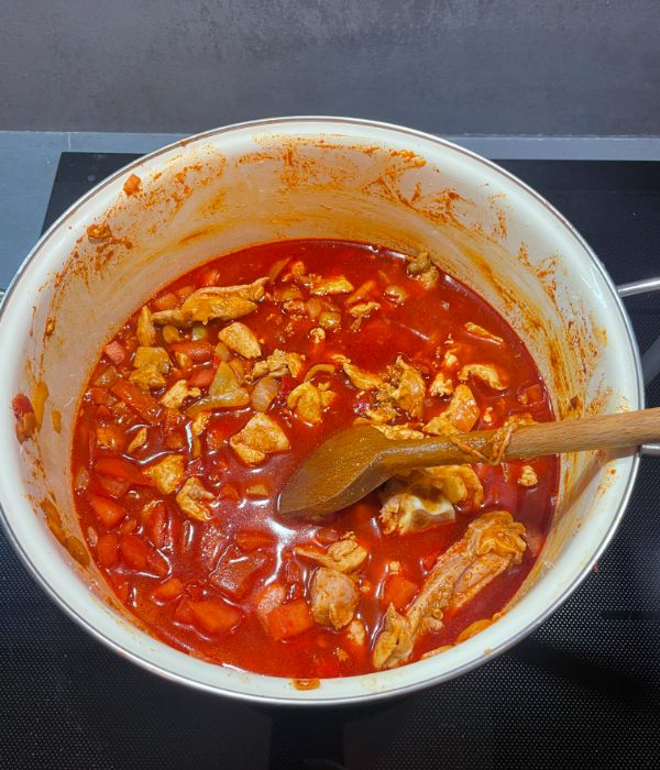 stirring chicken goulash with a spatula