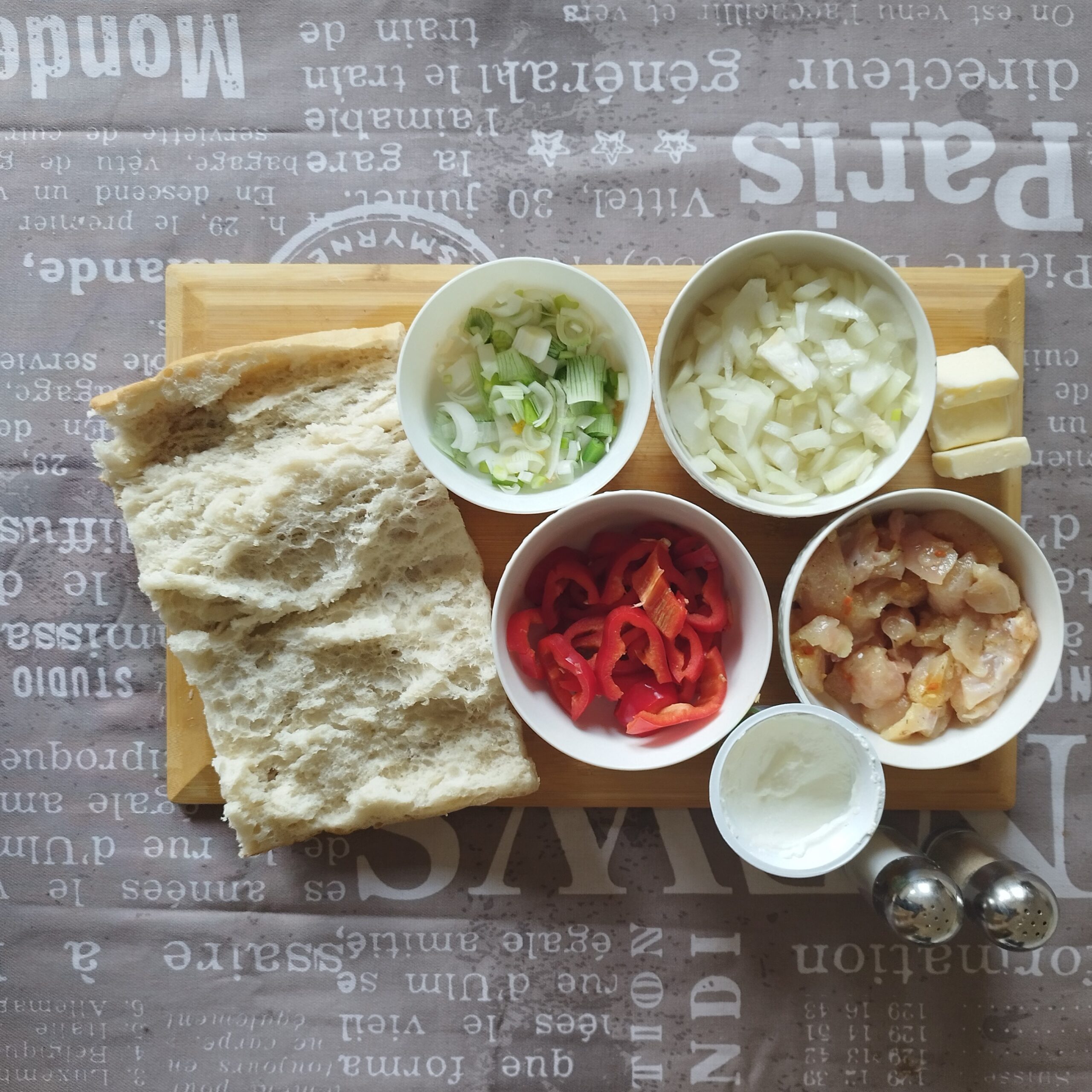 Ingredients for breakfast chicken sandwich shown: butter, sour cream, flatbread, onions, spring onions, bell peppers, salt, pepper