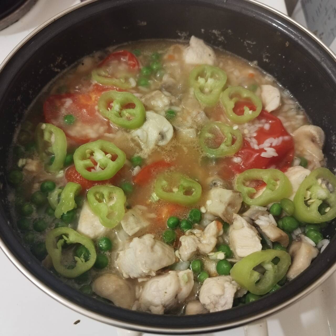 mushrooms, chicken, green peppers, rice, tomato, in a cooking-pot