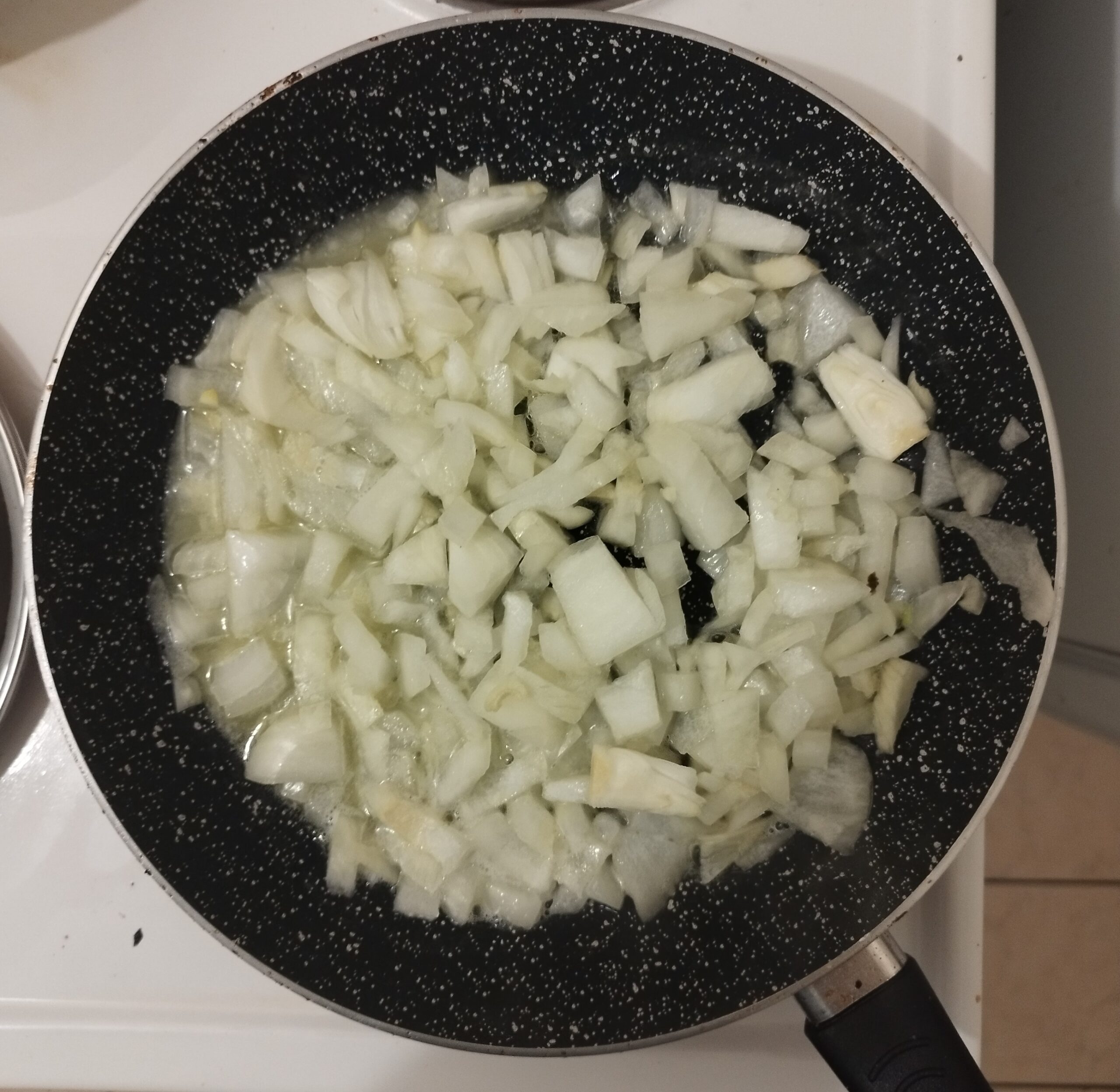 Onions being fried in a frying pan on butter